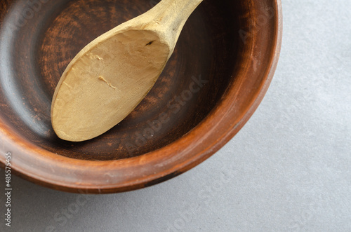 Photography Brown earthenware bowl and buckshot against a gray background.