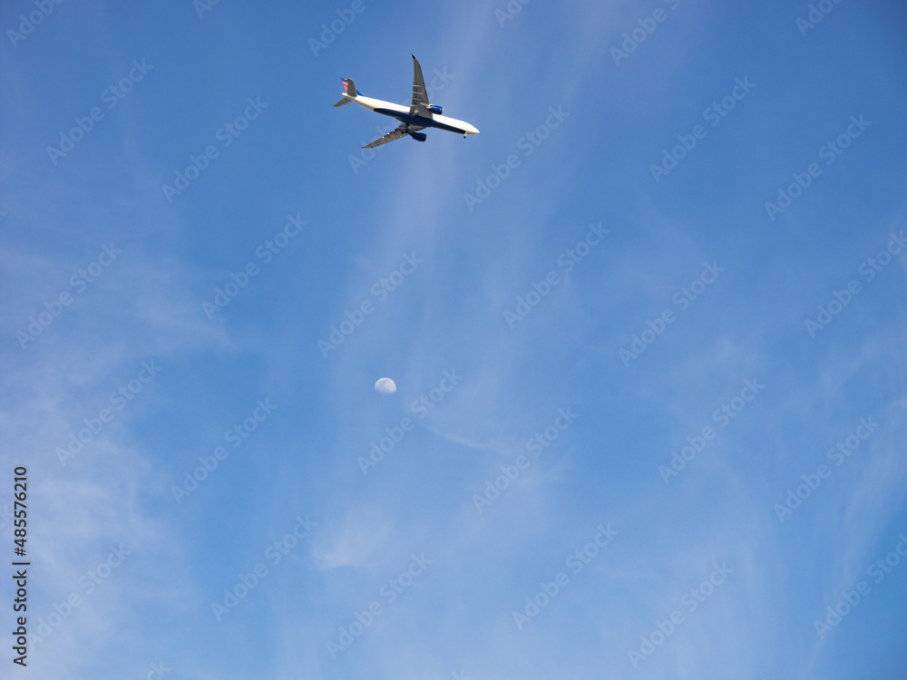 Fototapeta premium 見上げた空に見えた飛行機と月。
