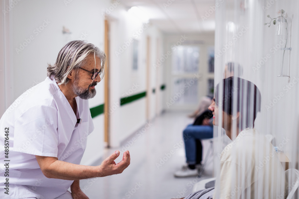 Doctor talking to patient in hospital corridor Doctor talking to patient in hospital corridor