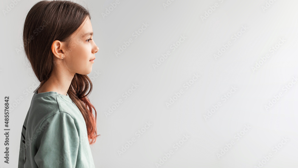 Side View Of Serious Girl Standing Looking Aside, Gray Background Side View Of Serious Girl Standing Looking Aside, Gray Background
