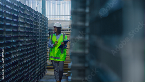 Female warehouse supervisor inspecting blue supply boxes analysing shipment © stockbusters