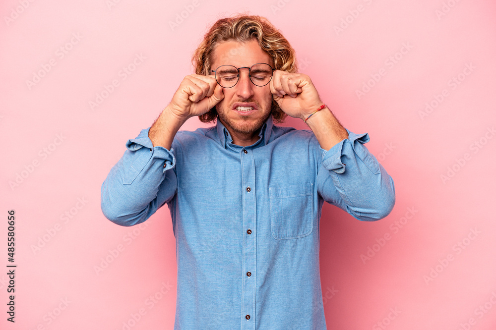 Young caucasian man isolated on pink background whining and crying disconsolately. Young caucasian man isolated on pink background whining and crying disconsolately.