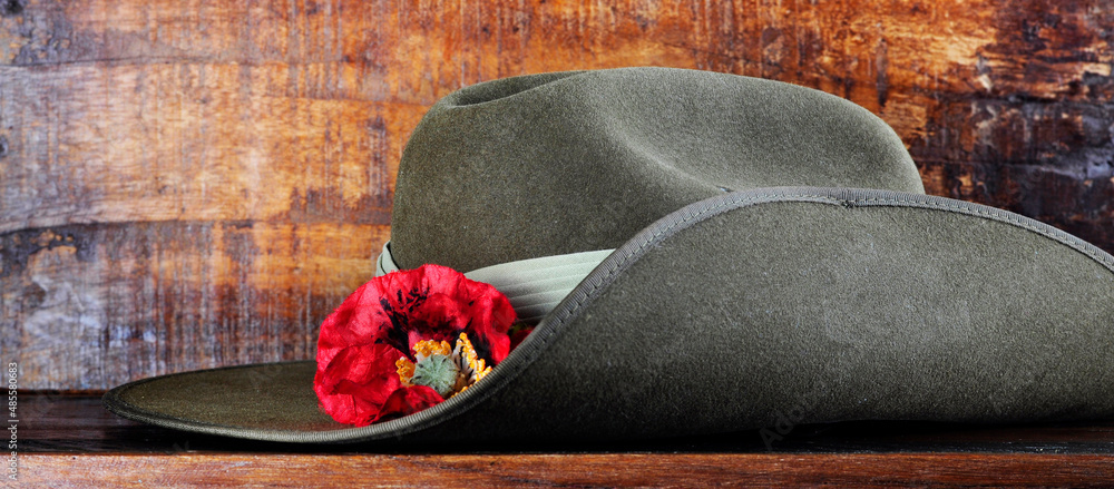 Australian army slouch hat on dark recycled wood with remembrance red poppy  for Anzac Day or Remembrance Armistice Day. Sized to fit popular social  media and web banner placeholder. Stock Photo