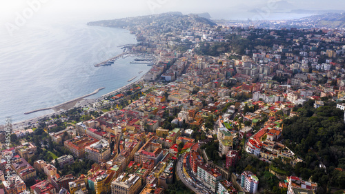 Aerial view of the city of Naples and the seafront of Mergellina on a sunny day. The Posillipo district in the background.