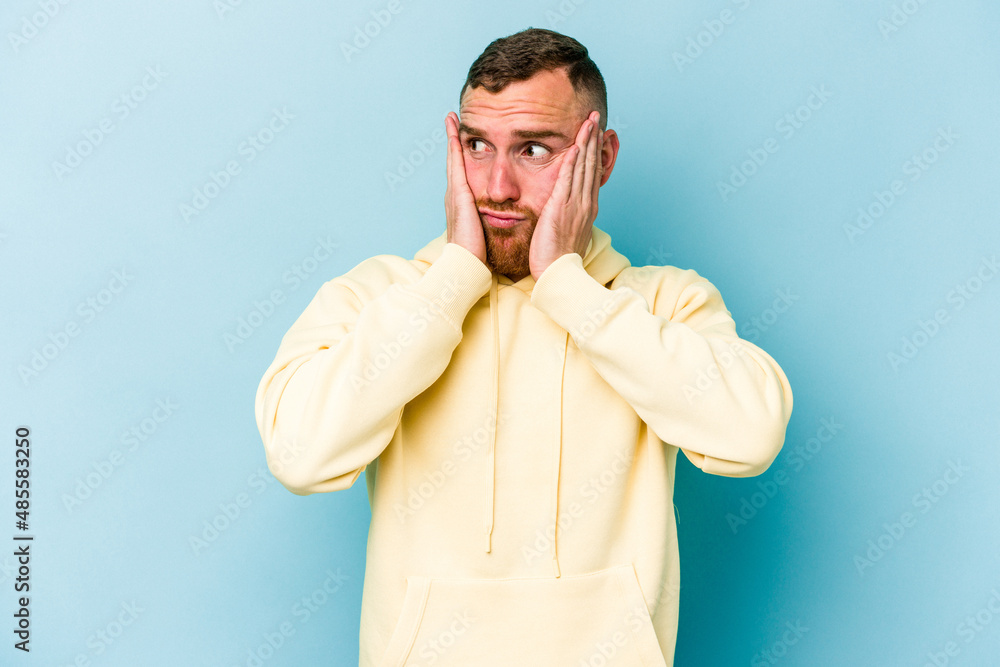 Young caucasian man isolated on blue background scared and afraid. Young caucasian man isolated on blue background scared and afraid.