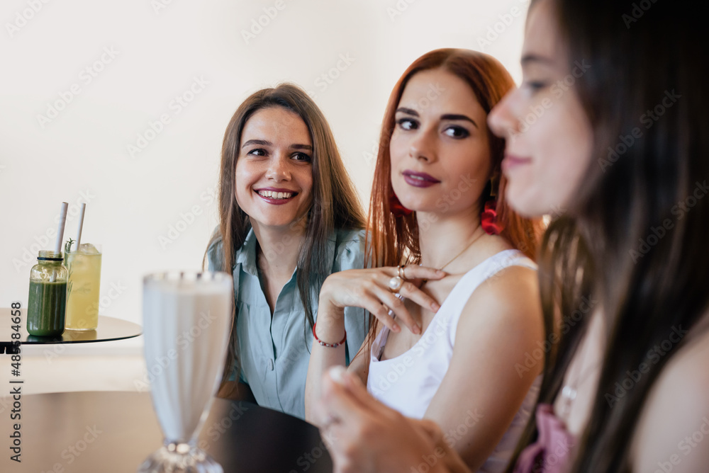 Three happy positive sisters dining in cafe and talking Three happy positive sisters dining in cafe and talking