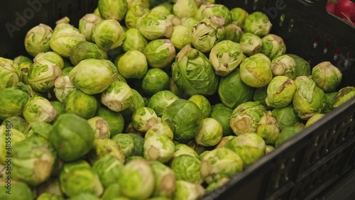 Plastic Crate Box Of Fresh Brussels Sprouts in Grocery Store Vegetables Stand	
