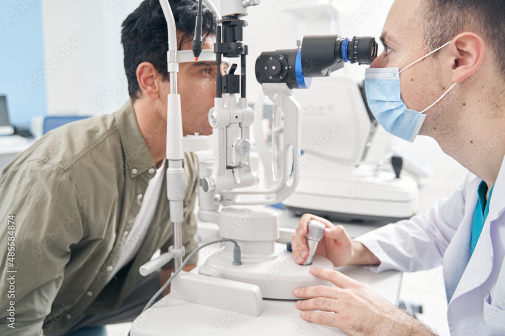 Male having eye examination by doctor in hospital Male having eye examination by doctor in hospital
