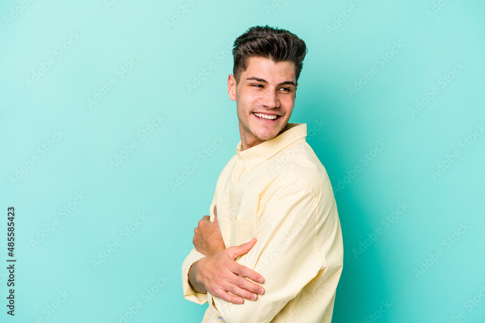 Young caucasian man isolated on blue background laughing and having fun. Young caucasian man isolated on blue background laughing and having fun.