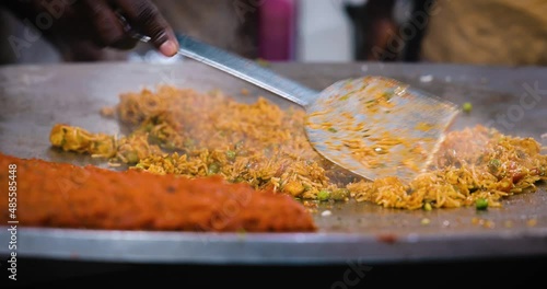 A chef preparing a popular Indian fast food Rice dish Tawa Pulao, Pulav, Biryani, Fried Rice in a hot pan. It is a mix of fresh vegetables, spices and rice. Juhu beach, Mumbai, Maharashtra, India 4804 photo