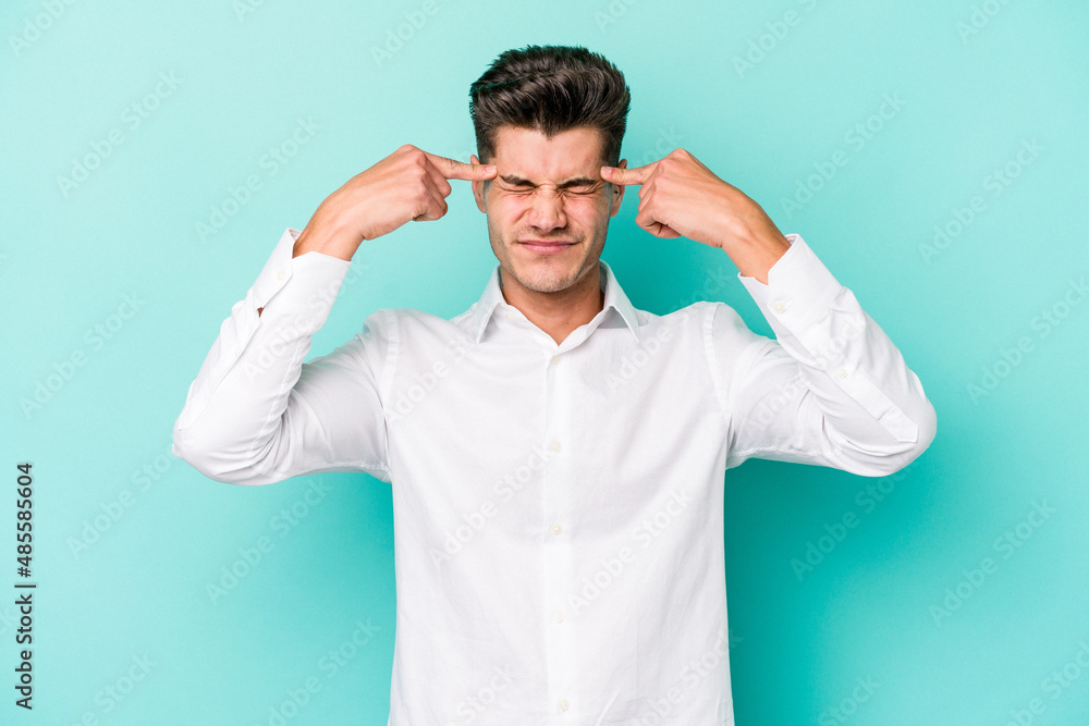 Naklejka premium Young caucasian man isolated on blue background focused on a task, keeping forefingers pointing head.