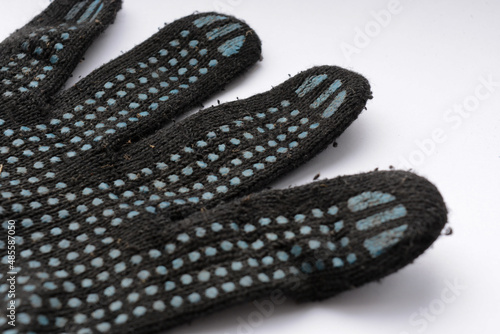 Black cotton work gloves with blue dots on white bakcground close up