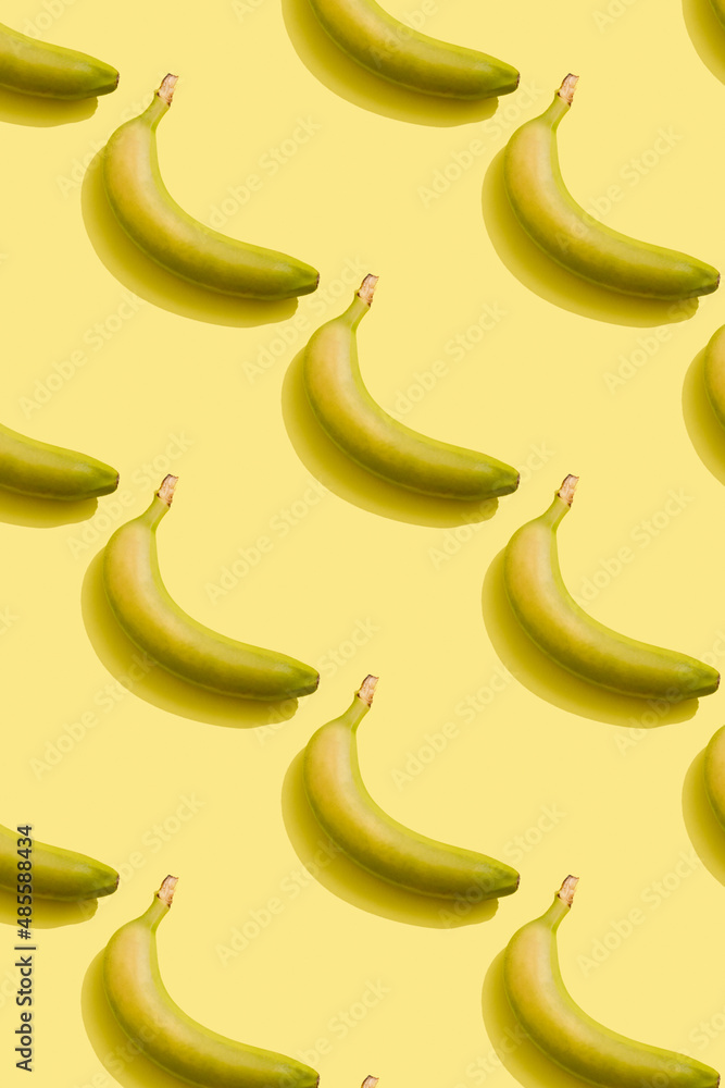 Pattern with bananas. Ripe yellow banana on a yellow background Pattern with bananas. Ripe yellow banana on a yellow background