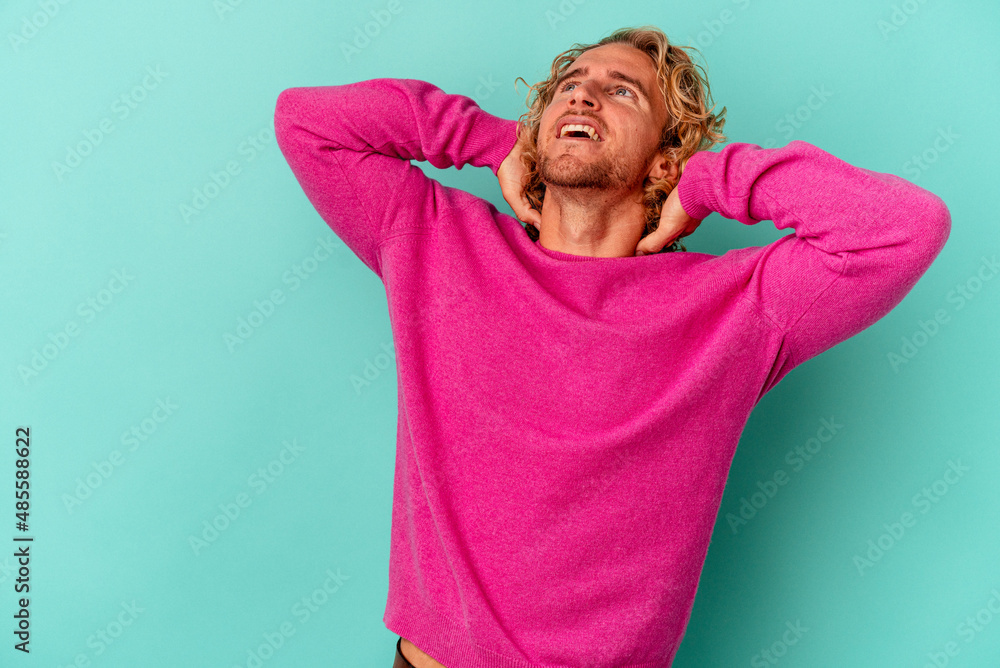 Young caucasian man isolated on blue background feeling confident, with hands behind the head. Young caucasian man isolated on blue background feeling confident, with hands behind the head.