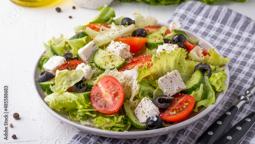 Salad with cherry tomatoes, cucumber, lettuce and cheese. Healthy food concept. Closeup