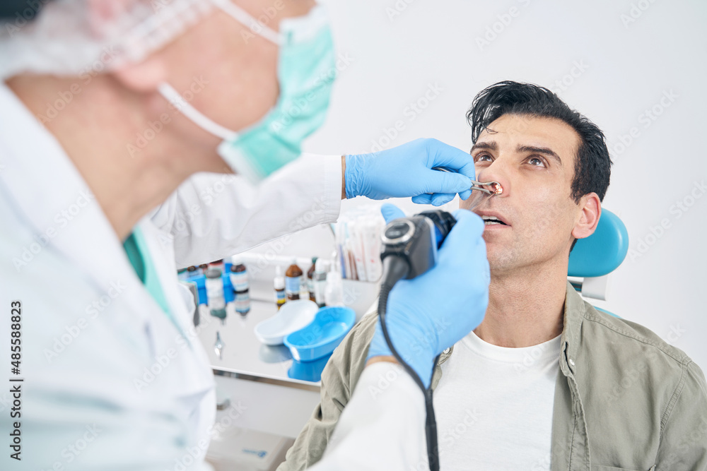 Otorhinolaryngologist working with medical instrument at the hospital Otorhinolaryngologist working with medical instrument at the hospital
