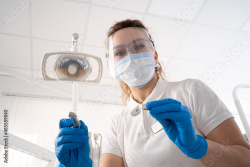 Dentist woman alone holding dental instruments, looking at the camera. Personal or patient point of view, POV. dental treatment concept.