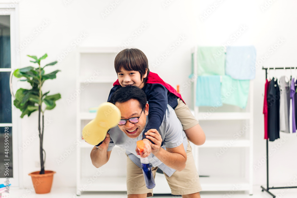 Portrait of enjoy happy love asian family father carrying little asian boy son smiling playing superhero and having fun moments good time on bed at home Portrait of enjoy happy love asian family father carrying little asian boy son smiling playing superhero and having fun moments good time on bed at home