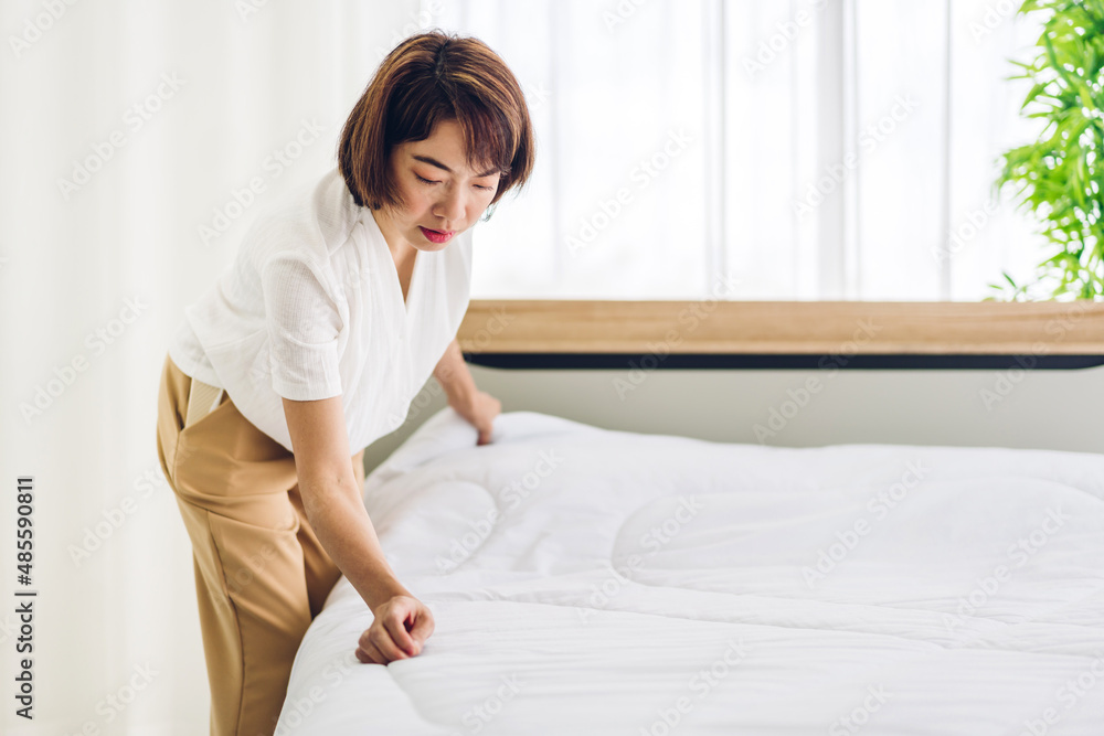 Young asian woman housewife clean bed and set up changing bedsheet with white clean sheet tidy up bedroom.room service and cleaning concept Young asian woman housewife clean bed and set up changing bedsheet with white clean sheet tidy up bedroom.room service and cleaning concept