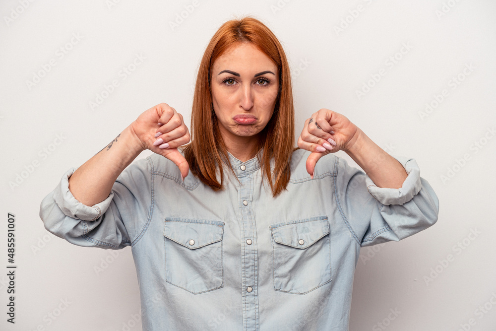 Young caucasian woman isolated on white background showing a dislike gesture, thumbs down. Disagreement concept. Young caucasian woman isolated on white background showing a dislike gesture, thumbs down. Disagreement concept.