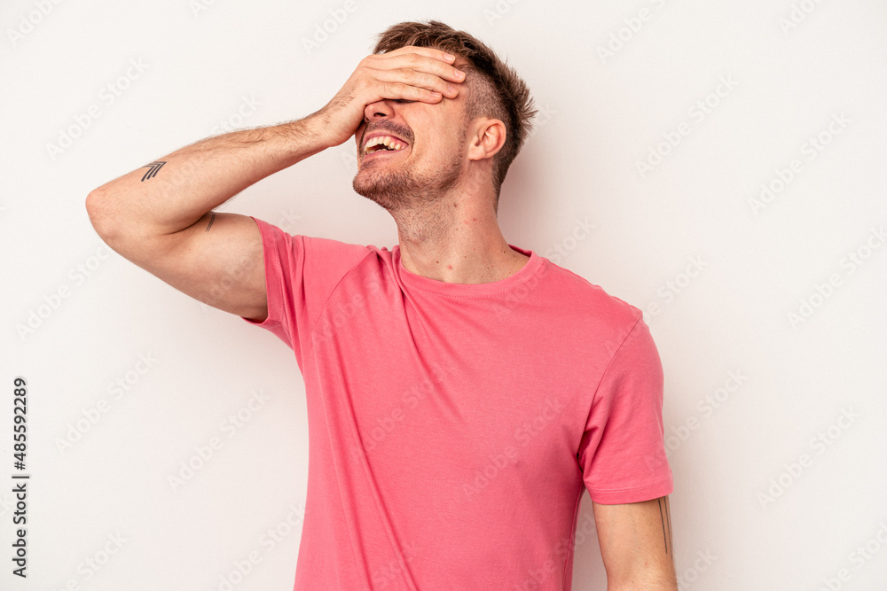 Obraz premium Young caucasian man isolated on white background covering ears with hands trying not to hear too loud sound.
