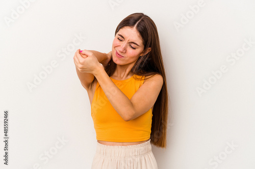 Young caucasian woman isolated on white background massaging elbow, suffering after a bad movement.