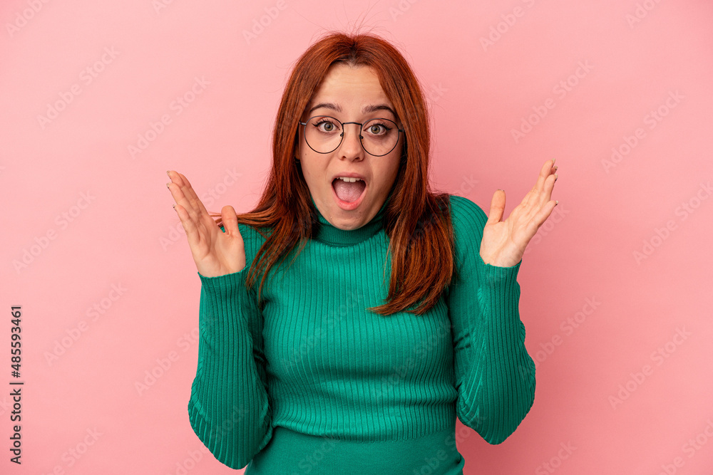 Young caucasian woman isolated on pink background celebrating a victory or success, he is surprised and shocked. Young caucasian woman isolated on pink background celebrating a victory or success, he is surprised and shocked.