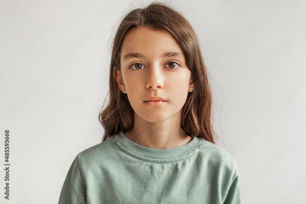 Portrait Of Serious Preteen Girl Looking At Camera, Gray Background Portrait Of Serious Preteen Girl Looking At Camera, Gray Background