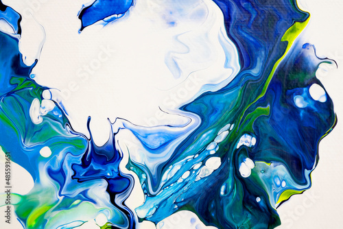 Bright spills of dark blue, blue, yellow colors on a white background. Modern abstract painting. A fragment of a work of art. Abstract colorful painting with liquid acrylic photo