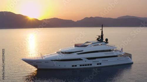 A superyacht moored in a calm sea at colorful sunset photo