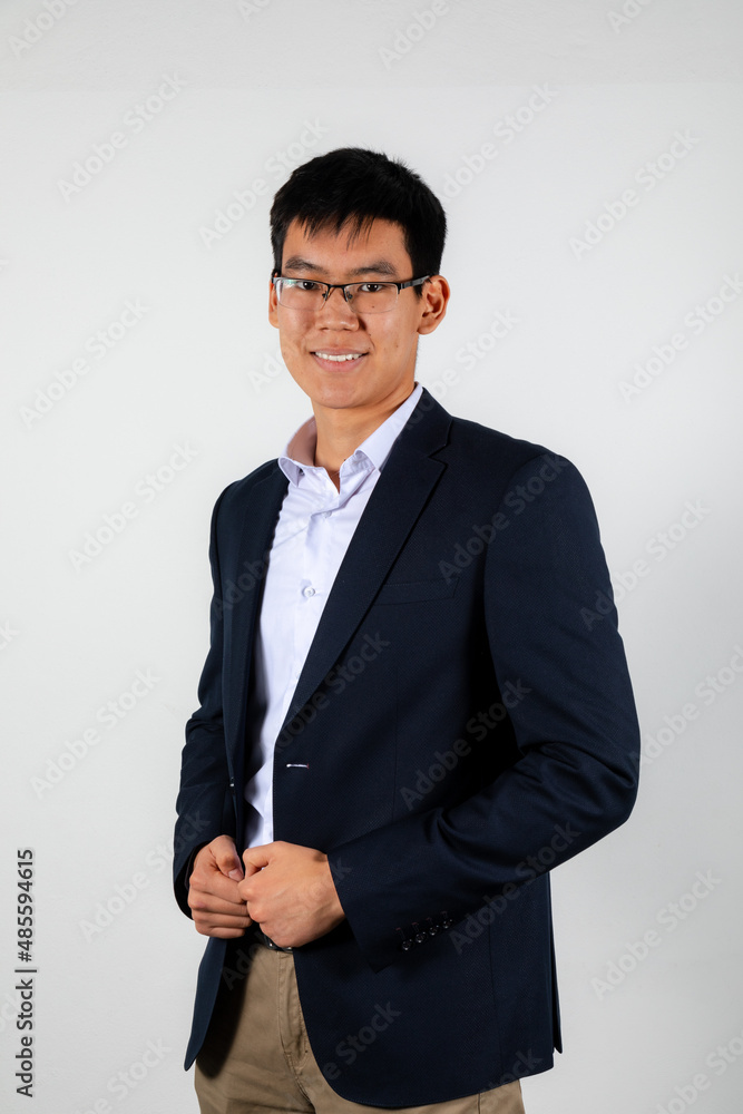 Young smiling asian man wearing glasses, black office jacket and white shirt Young smiling asian man wearing glasses, black office jacket and white shirt