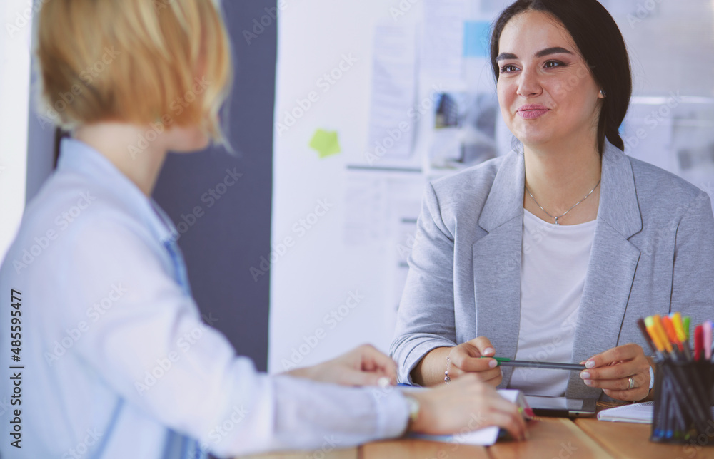 Fototapeta premium Young people studying with books on desk. Beautiful women and men working together.