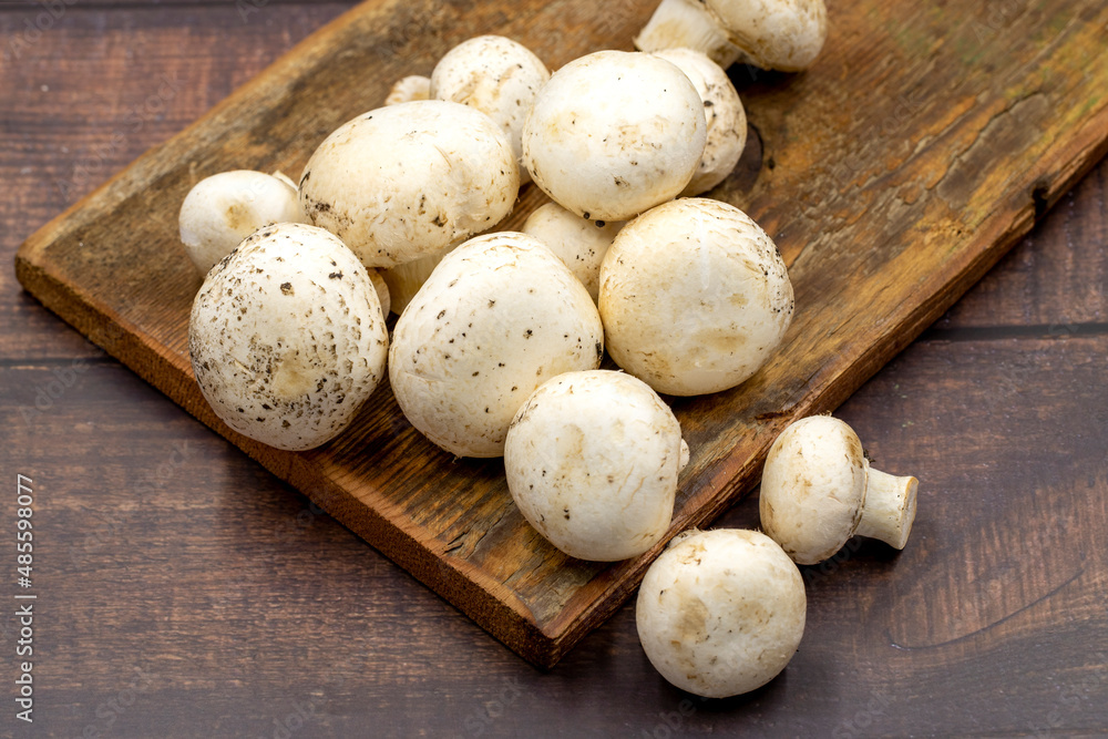 Organic mushrooms on a wooden background. Cultivated mushroom or portabello mushroom Organic mushrooms on a wooden background. Cultivated mushroom or portabello mushroom