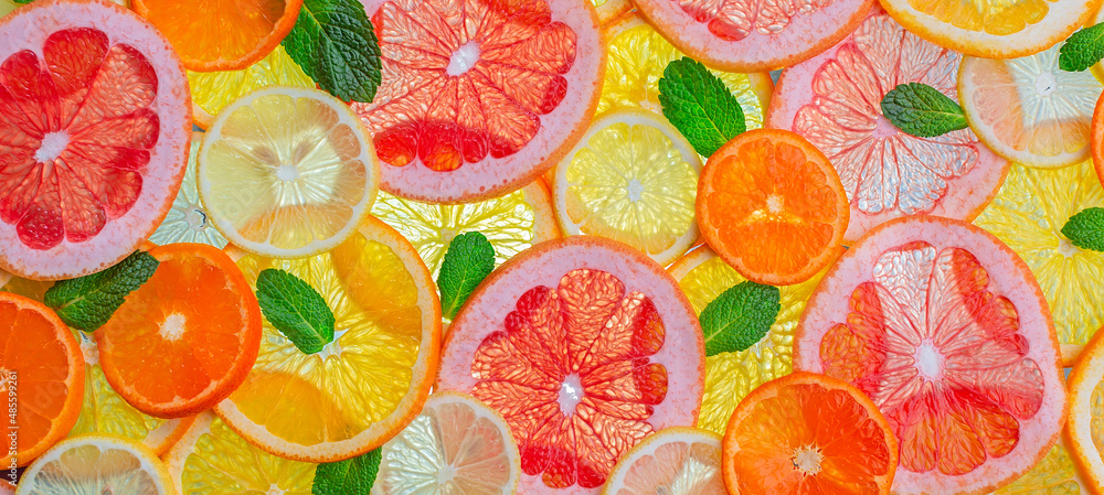 Ripe juicy citrus fruits are cut into slices and mint. Food background. Ripe juicy citrus fruits are cut into slices and mint. Food background.