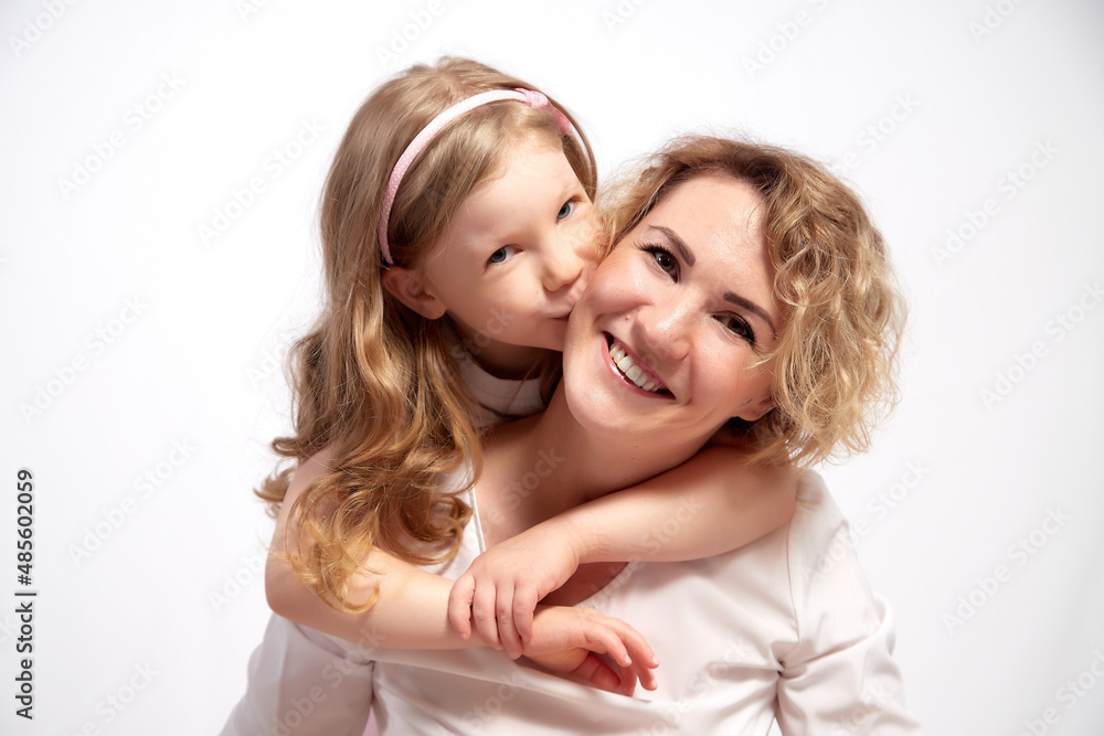 Nice mom and beautiful blonde daughter in room of the studio durin spring photo shoot before easter. Happy girl and woman together Nice mom and beautiful blonde daughter in room of the studio durin spring photo shoot before easter. Happy girl and woman together
