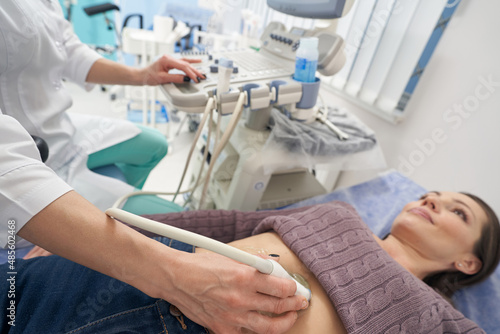 Serene young woman undergoing abdominal ultrasound examination