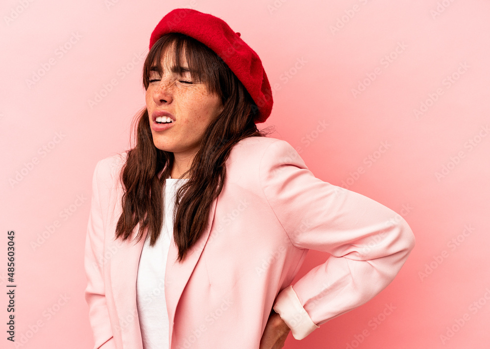 Young Argentinian woman isolated on pink background suffering a back pain.
