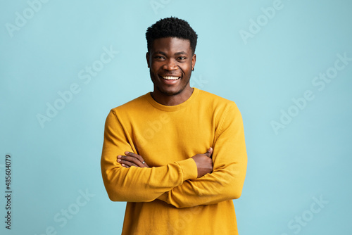 Handsome young black man posing alone on blue photo
