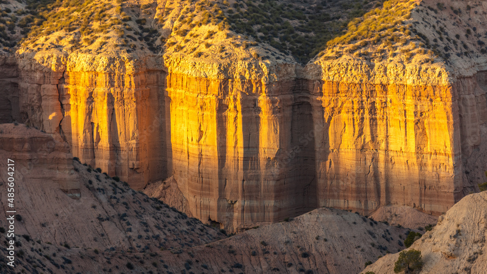 Close up of steep cliffs in the eroded badlands of the Gorafe desert, los Coloraos, at sunset, Andalusia, Spain
