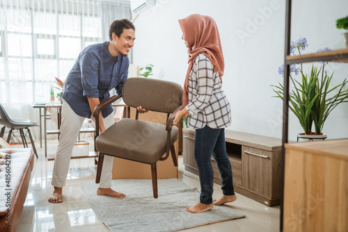 muslim young couple moving new chair at their new home