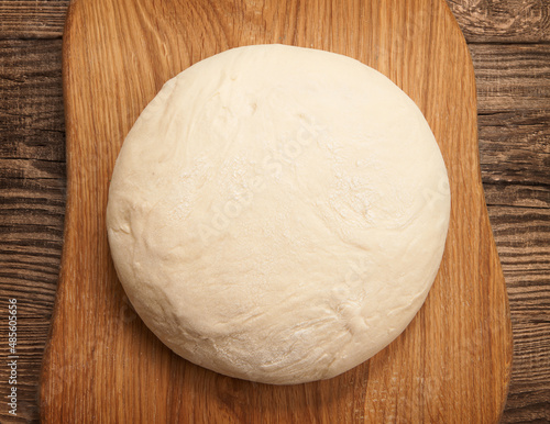 top view fresh raw dough for pizza or bread baking on wooden cutting board