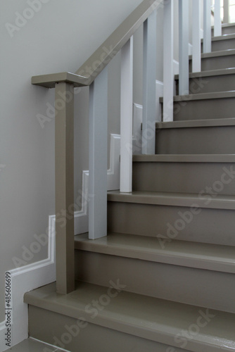 Grey walls, white railings and grey stairs of a modern house.