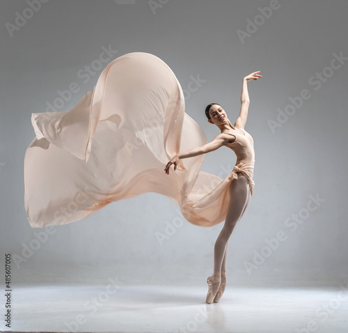 Beautiful ballerina dancing in the body color ballet leotard with body color cloth. She danced on ballet pointe shoes.