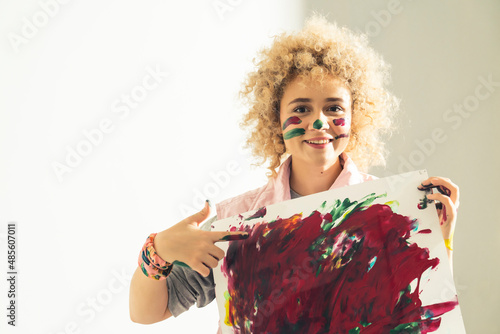 Young artist woman shows her abstract painting made with her hands. High quality photo