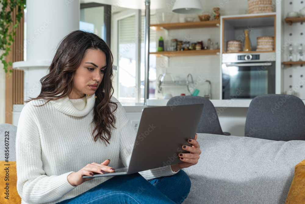 Fototapeta premium Young successful graphic designer woman sitting at home working as freelancer online marketing web developer. Female entrepreneur work on website design for online education and advertisement.