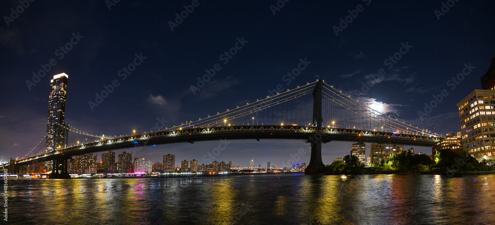 Manhattan Bridge under the full moon night landscape. This amazing constructions is one of the most known landmarks in New York.