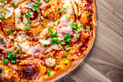 Pizza with chicken and barbeque sauce. Italian pizza on wooden table background