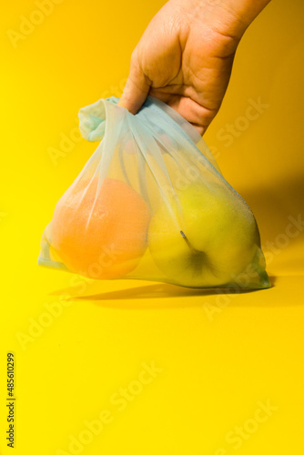  Fruit lies in a reusable bag for shopping on a yellow background. Vertical photo. High quality photo