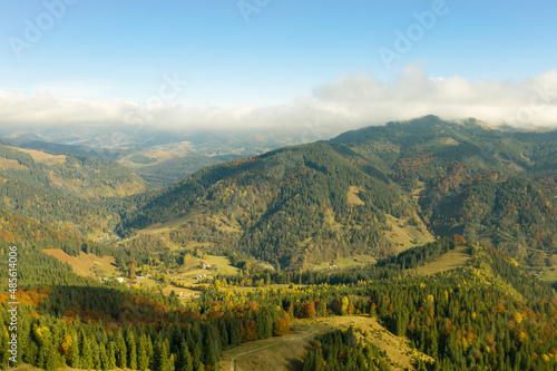 Aerial view of beautiful mountain forest and village on autumn day © New Africa