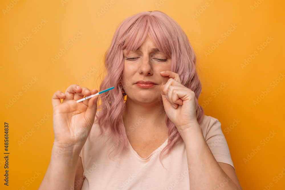 Sad woman complaining holding a pregnancy test, long awaited pregnancy. Sad woman complaining holding a pregnancy test, long awaited pregnancy.